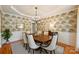 Formal dining room with elegant wallpaper, wainscoting, chandelier, and a dark wood dining table at 16430 New Providence Ln, Charlotte, NC 28277