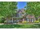 Traditional two-story brick home with a welcoming front porch and well-manicured landscaping at 16430 New Providence Ln, Charlotte, NC 28277