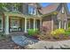 Charming front porch with white columns, complemented by lush, colorful landscaping and a brick walkway at 16430 New Providence Ln, Charlotte, NC 28277