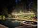 Inviting backyard pool and spa illuminated by string lights at night, offering a relaxing outdoor space at 16430 New Providence Ln, Charlotte, NC 28277