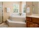 Bright bathroom featuring a soaking tub with tile surround, and tiled floors, plus a glass shower stall at 1666 Sam Smith Rd, Fort Mill, SC 29708