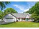 Charming single-story home with a teal front door, lush green lawn, and a welcoming front porch at 1666 Sam Smith Rd, Fort Mill, SC 29708