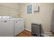 Efficient laundry room with Maytag appliances, shelving and modern trash receptacle on wood laminate floors at 1666 Sam Smith Rd, Fort Mill, SC 29708
