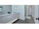 Modern bathroom featuring a double sink vanity, stone countertops, and a glass-enclosed shower at 1919 Shoreham Dr, Charlotte, NC 28211