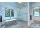 Bright bathroom with a glass shower, soaking tub, and large window at 1919 Shoreham Dr, Charlotte, NC 28211