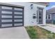 Close up of a modern looking black garage door next to the front door of the house with the address number at 2006 Upstate Way, Charlotte, NC 28206