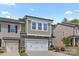 A green, two-story townhouse has an attached garage, green shingles, white trim and beautiful landscaping at 2034 Suttonview Rd, Fort Mill, SC 29708