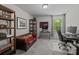 Office with red leather sofa, desk, TV, shelves, and lots of natural light at 2034 Suttonview Rd, Fort Mill, SC 29708