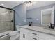 This bathroom features a glass-enclosed shower and double sinks with black hardware and modern white cabinets at 2362 Marett Blvd, Rock Hill, SC 29732