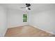 Cozy bedroom featuring wood-look floors, a window, neutral walls, and modern ceiling fan at 2530 Cochrane Dr, Charlotte, NC 28269