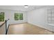 Bright bedroom with natural light, featuring hardwood floors and large windows overlooking greenery at 2530 Cochrane Dr, Charlotte, NC 28269