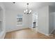 Bright dining area featuring hardwood floors, a modern chandelier, and a window view at 2530 Cochrane Dr, Charlotte, NC 28269