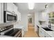 Modern kitchen with stainless steel appliances, white cabinets, subway tile backsplash, and hardwood floors at 2530 Cochrane Dr, Charlotte, NC 28269