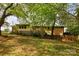 Spacious backyard with deck, mature trees, wooden fence, and partial view of brick home at 3012 Morgan Mill Rd, Monroe, NC 28110