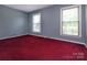 Bright bedroom with two large windows, neutral-toned walls, and red carpet, offering ample natural light at 3012 Morgan Mill Rd, Monroe, NC 28110