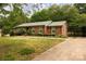 Single story brick home with a well manicured lawn, metal roof, and concrete driveway at 3012 Morgan Mill Rd, Monroe, NC 28110