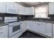 Bright kitchen features white cabinets, black and grey backsplash, and dark, shiny flooring at 3012 Morgan Mill Rd, Monroe, NC 28110