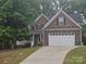 Charming two-story home features a two car garage and a combination of stone, siding, and shake exterior finishes at 4203 Flint Dr, Lancaster, SC 29720
