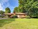 Charming single-story brick home featuring a covered carport, colorful flowers, and a well-maintained lawn at 437 Old Mountain Rd, Statesville, NC 28677