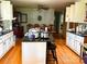 Kitchen featuring a black granite island, white cabinets, wood floors and an eat-in dining area at 437 Old Mountain Rd, Statesville, NC 28677