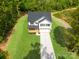 Aerial view of a two-story home with an attached garage, and a long driveway on a lush, green lot at 5115 Carden Dr, Charlotte, NC 28227