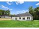 Lush backyard with an immaculate lawn and a rear elevation of the bright white house at 5125 Carden Dr, Charlotte, NC 28227