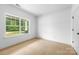 Bright bedroom featuring a large window with views of nature and a door to another room at 5125 Carden Dr, Charlotte, NC 28227