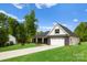 Charming home featuring a covered porch, a two-car garage, and a well-manicured lawn at 5125 Carden Dr, Charlotte, NC 28227