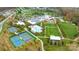 Aerial view showcases the community amenities, featuring tennis courts, swimming pool, and large lawn area at 5247 Looking Glass Trl, Denver, NC 28037
