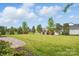Expansive front yard boasting a lush lawn, mature trees, and meticulously maintained landscaping at 5247 Looking Glass Trl, Denver, NC 28037