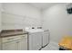 Efficient laundry room with washer, dryer, ample counter space, shelving, and storage for convenience at 5247 Looking Glass Trl, Denver, NC 28037
