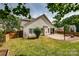 A spacious backyard with a paver patio and fire pit, surrounded by green grass, and mature landscaping at 6001 Pine Cone Ln, Monroe, NC 28110
