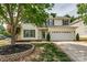 Charming two-story home with manicured lawn and attached two-car garage at 6001 Pine Cone Ln, Monroe, NC 28110