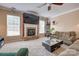 Cozy living room featuring a stone fireplace, large TV, and comfortable seating, perfect for relaxing and entertaining at 6001 Pine Cone Ln, Monroe, NC 28110
