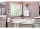 Bright bathroom featuring an oval soaking tub, modern fixtures, and a large window with natural light at 618 Chase Ct, Fort Mill, SC 29708