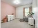 Bedroom with pink accent wall, dresser, comfy chair, curtains and a window at 618 Chase Ct, Fort Mill, SC 29708
