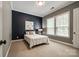 Bedroom with a navy accent wall, neutral carpet, white bed, natural light from windows at 618 Chase Ct, Fort Mill, SC 29708