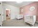 This bedroom has light carpet, a pink accent wall and two cribs at 618 Chase Ct, Fort Mill, SC 29708