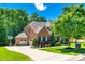 Beautiful two-story brick home with a three-car garage, lush landscaping, and a well-manicured lawn at 618 Chase Ct, Fort Mill, SC 29708