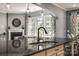 Close-up of granite island sink in kitchen with view into fireplace and living room at 618 Chase Ct, Fort Mill, SC 29708