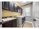 Well-equipped laundry room with cabinets, sink, and modern washer and dryer at 618 Chase Ct, Fort Mill, SC 29708
