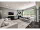 Living room with a fireplace, large windows, and comfortable seating arrangement at 618 Chase Ct, Fort Mill, SC 29708