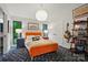 Bright bedroom with an orange platform bed, modern lighting, and unique decor at 6508 Trenton Pl, Charlotte, NC 28226