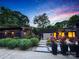 Charming home with lush landscaping, stone pathway, vibrant flowers, and modern lighting accents at dusk at 6508 Trenton Pl, Charlotte, NC 28226