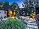 Beautifully landscaped front yard with lush greenery, stone accents, and a modern pergola at twilight at 6508 Trenton Pl, Charlotte, NC 28226