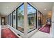 The bright hallway features large windows looking out at a lush indoor garden, bringing nature indoors at 6508 Trenton Pl, Charlotte, NC 28226