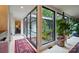 Bright hallway featuring large windows overlooking a serene indoor garden area with vibrant plants and natural light at 6508 Trenton Pl, Charlotte, NC 28226