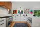 A modern kitchen features white cabinetry, stainless steel appliances, and quartz countertops with backyard view at 6508 Trenton Pl, Charlotte, NC 28226