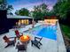 Stunning outdoor pool area with a fire pit, in-pool seating, and a covered dining space for entertaining at 6508 Trenton Pl, Charlotte, NC 28226