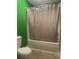 Bathroom with a matching toilet and bathtub with white tiles and a closed white shower curtain with green walls at 734 Harris Nw St, Concord, NC 28025